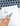 Hand holding a pen over a blank prescription pad on a laptop keyboard.